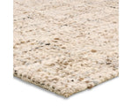 A beige wool area rug with a textured weave pattern.