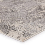 Close-up of a textured gray and beige area rug on a white background