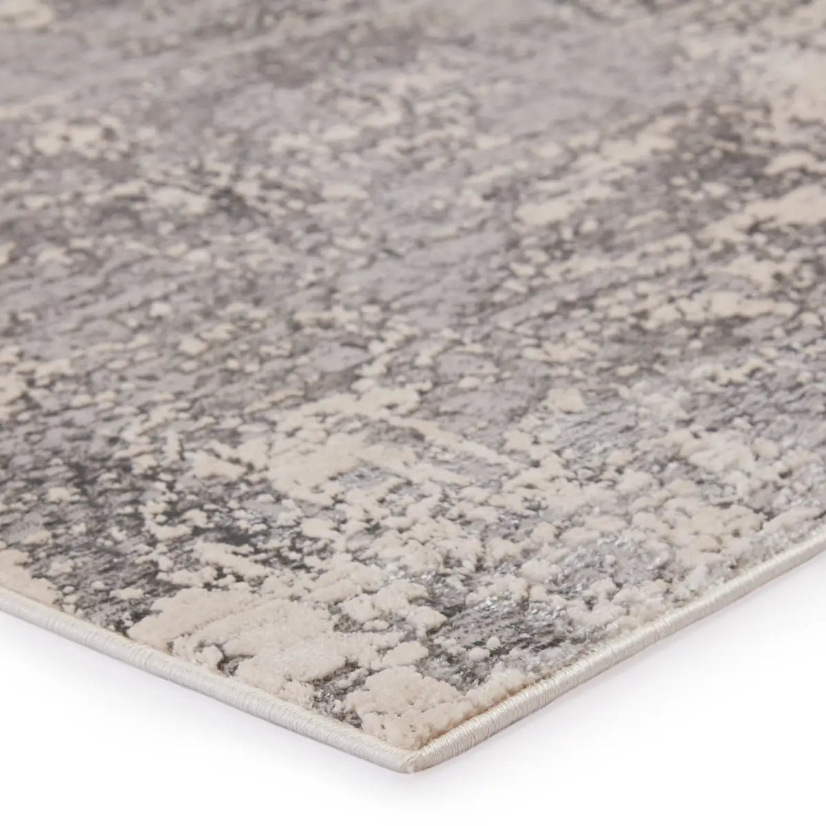 Close-up of a textured gray and beige area rug on a white background