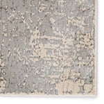 Close-up of a textured rug with a geometric pattern in gray and beige.