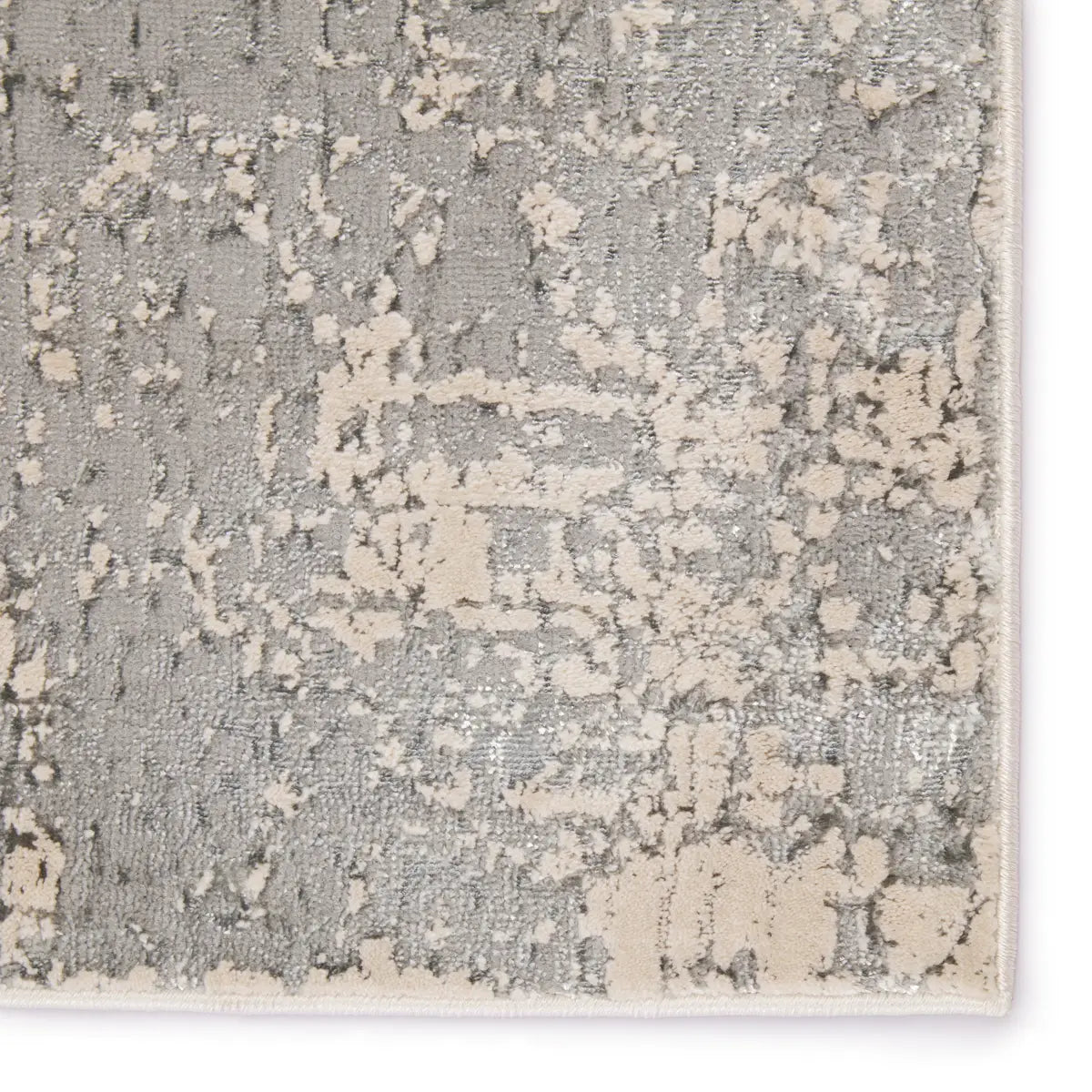 Close-up of a textured rug with a geometric pattern in gray and beige.