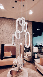 Modern living room with a decorative light fixture spelling 'LOVE'.