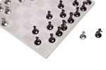 A beige marble chess board set with white and black pieces arranged on the board.