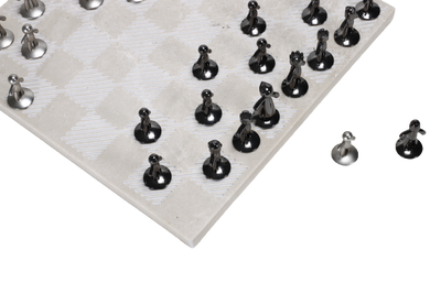 A beige marble chess board set with white and black pieces arranged on the board.