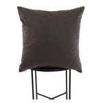 Dark brown pillow on a black stool against a white background