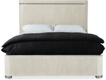 Beige upholstered bed with black bedding on a white background