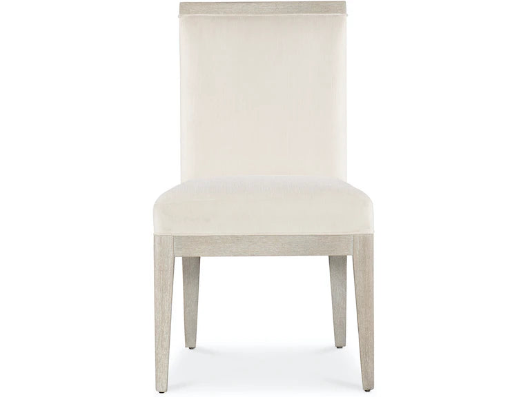 A beige upholstered dining chair with a high back and four legs.