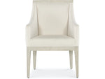 A beige upholstered dining chair with armrests and wooden legs, viewed from a front angle.
