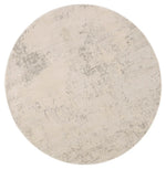A power loomed round area rug with a textured design in beige and gray tones 