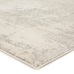 A power loomed area rug with a textured design in beige and gray tones.