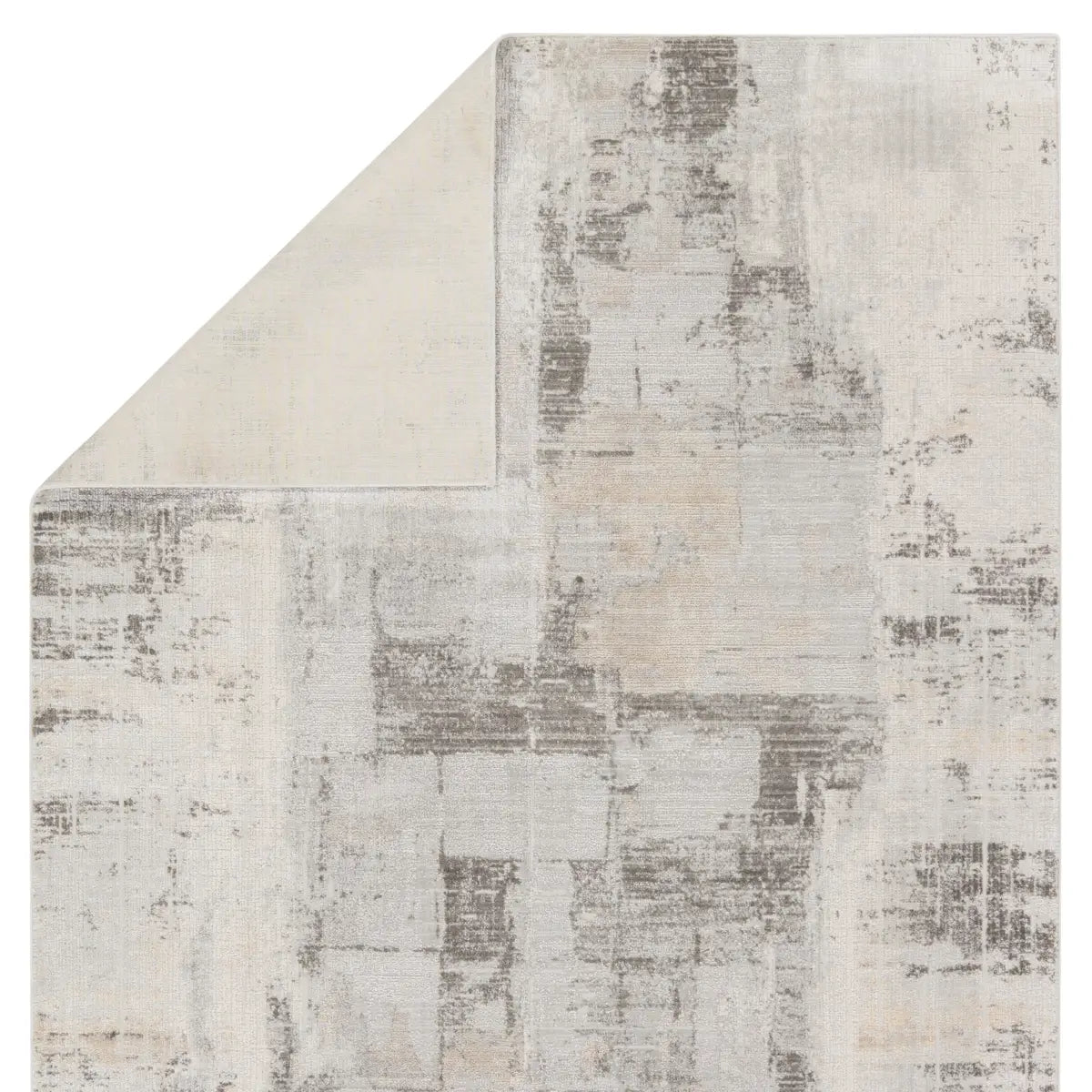 A white area rug with a geometric pattern featuring various shades of grey and a subtle wood floor appearance.