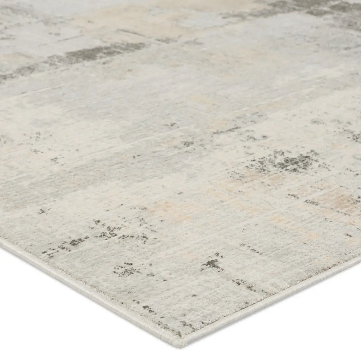 A white area rug with a geometric pattern featuring various shades of grey and a subtle wood floor appearance.