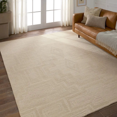 Beige rug in a living room with a brown sofa and large windows.