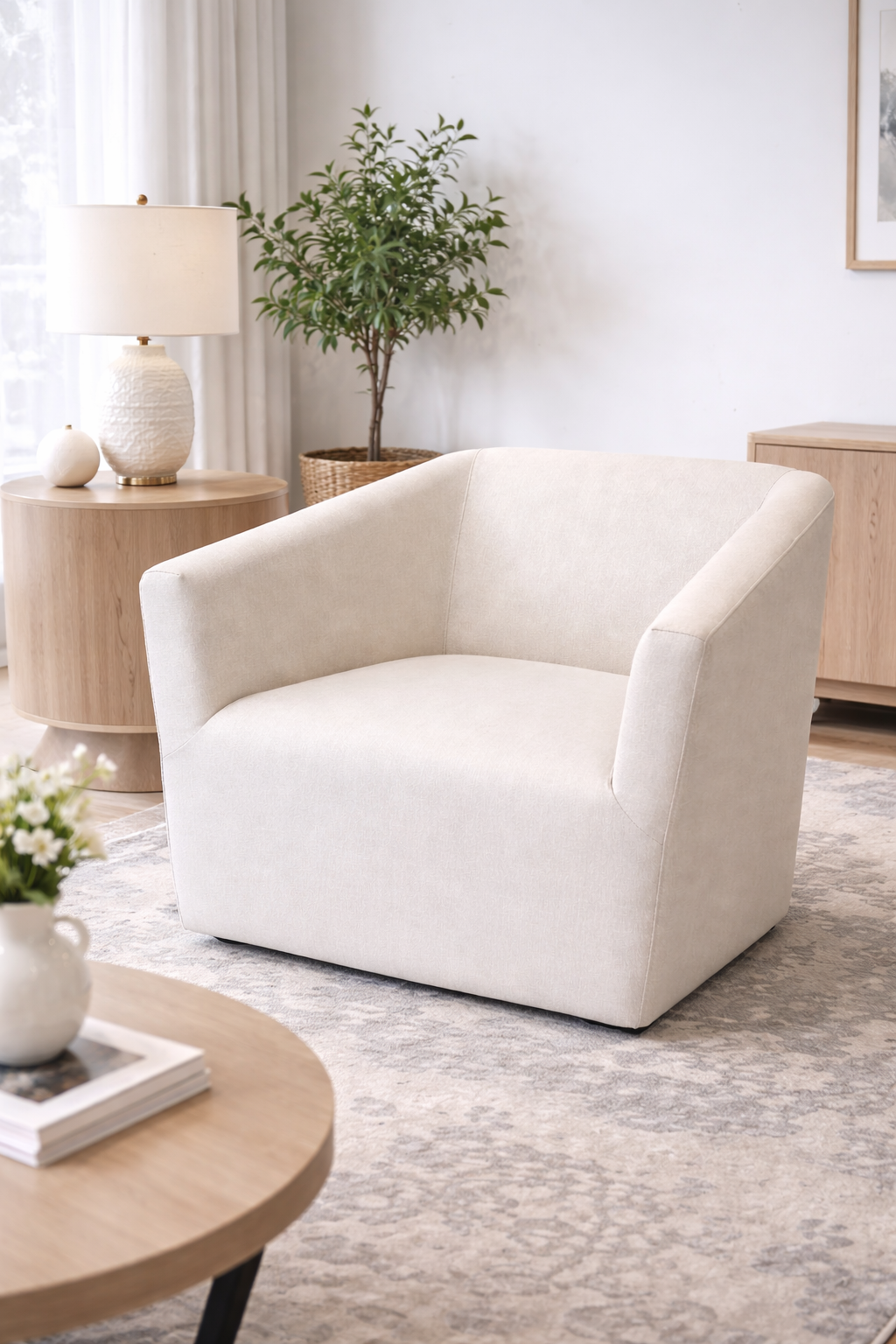 White armchair in a living room setting with a lamp, plant, and coffee table.