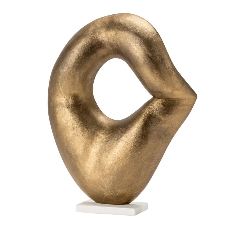 A gold-colored, curvilinear decorative artwork on a white base.