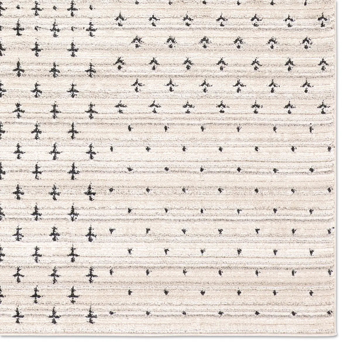 Patterned rug with small black shapes on a beige background