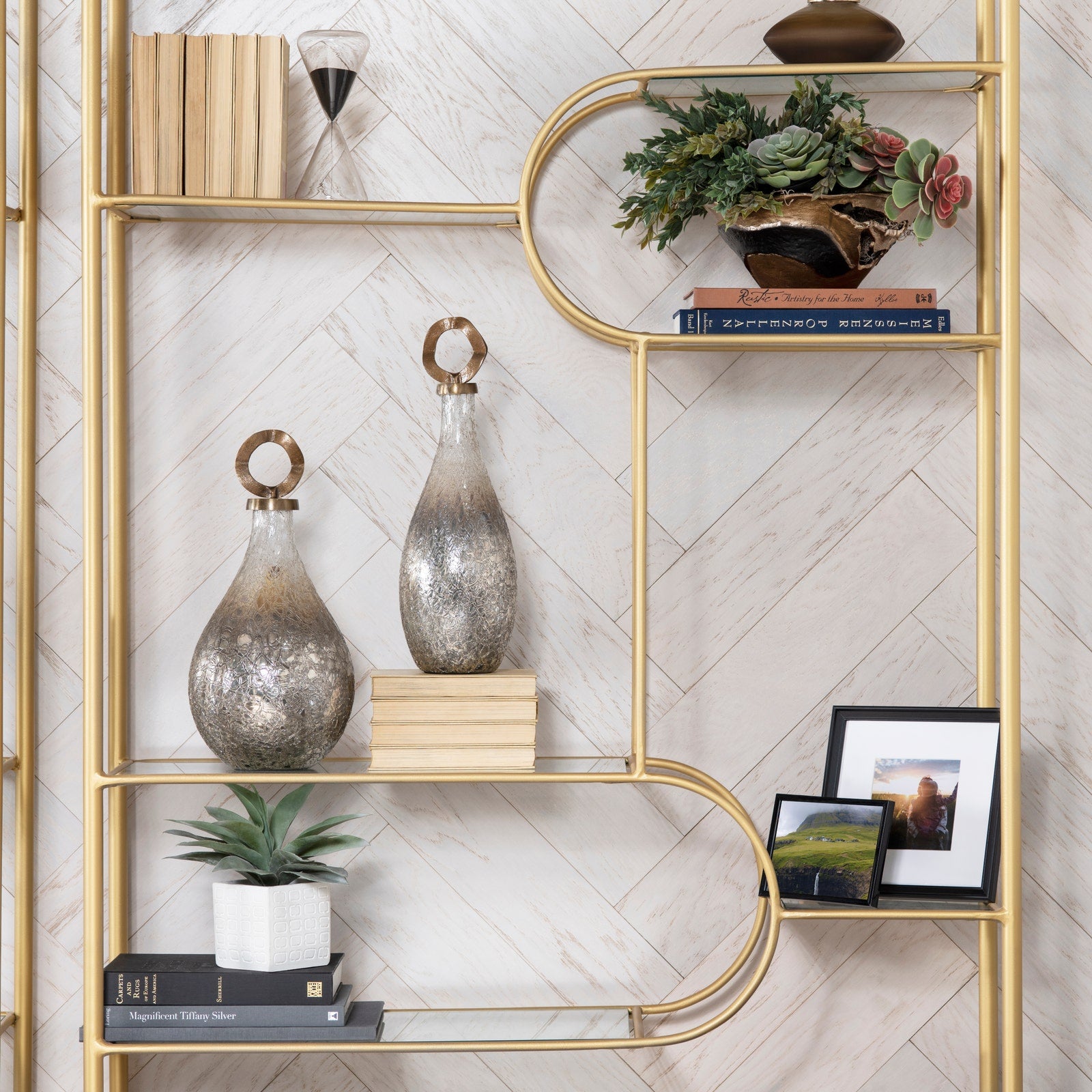 Gold shelving unit with decorative items against a white wall.