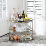 Three-tiered gold bar cart with drinks and glasses in a home setting