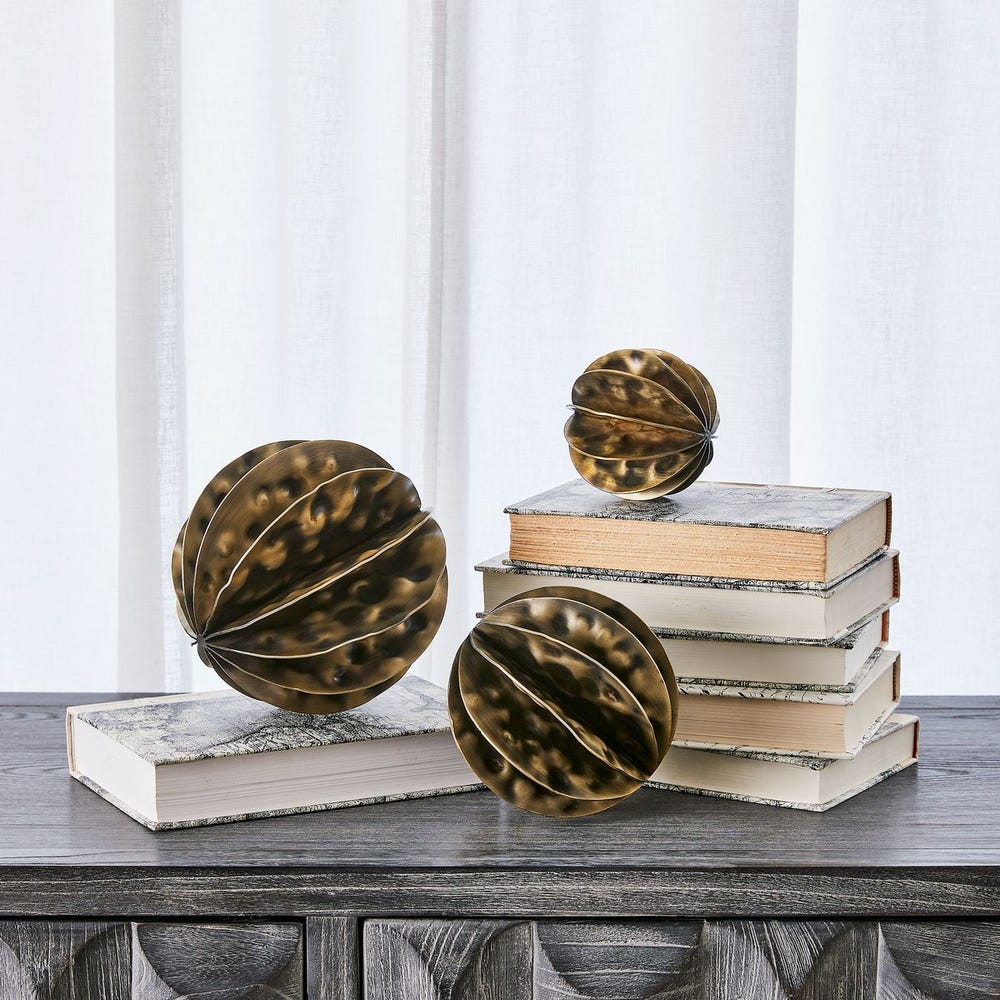 Decorative spherical objects on books with a white curtain background