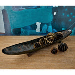 Decorative tray with star-shaped objects on a wooden surface with a blue abstract painting in the background.