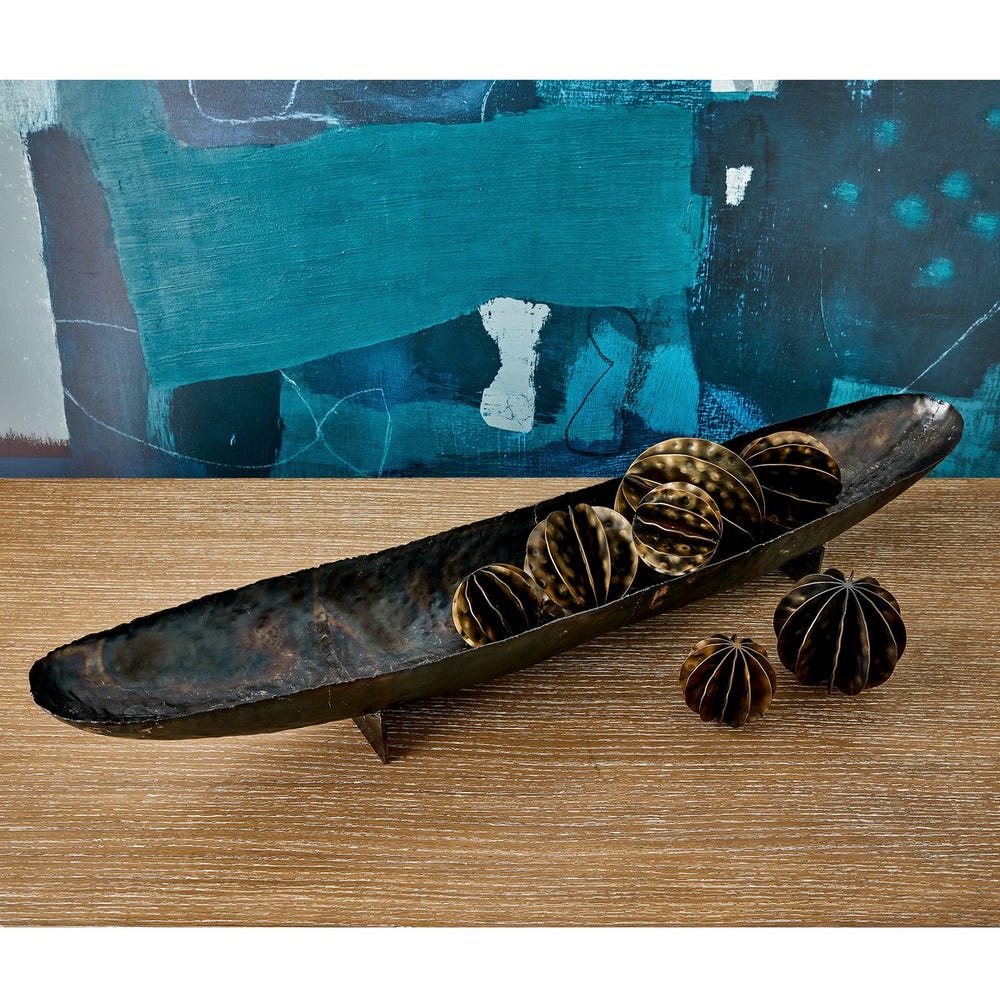 Decorative tray with star-shaped objects on a wooden surface with a blue abstract painting in the background.