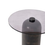 Glass top table with a dark cylindrical base on a white background
