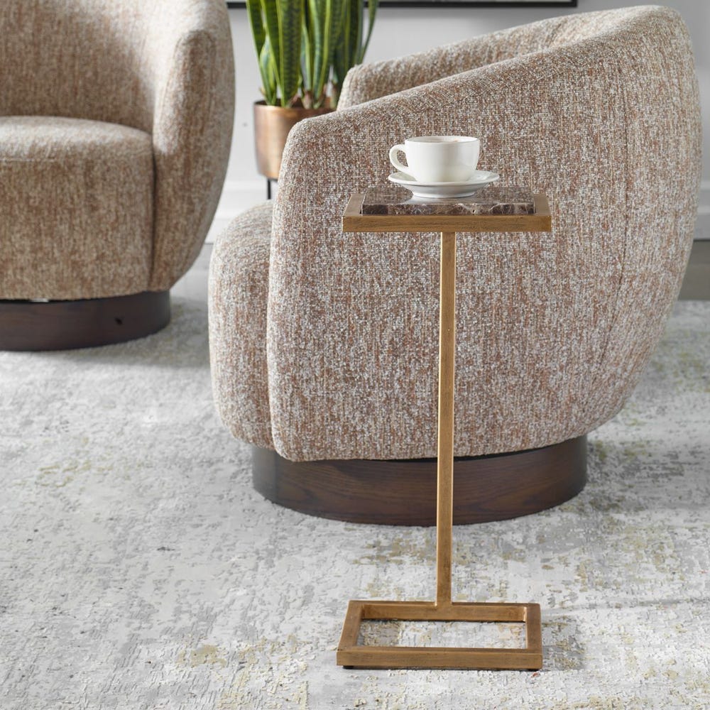 Beige armchair with a small wooden side table and a cup on a white saucer.