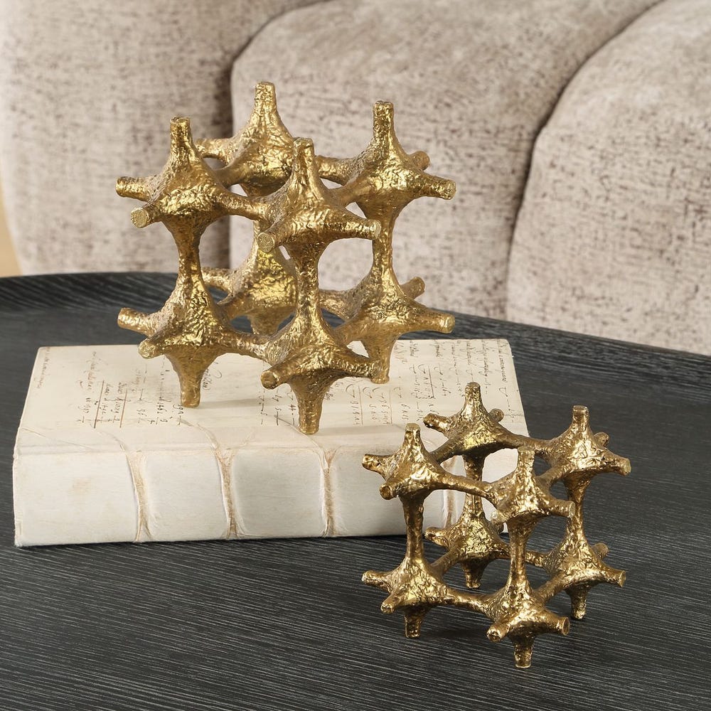 Gold decorative items resembling starfish on a book with a textured surface background