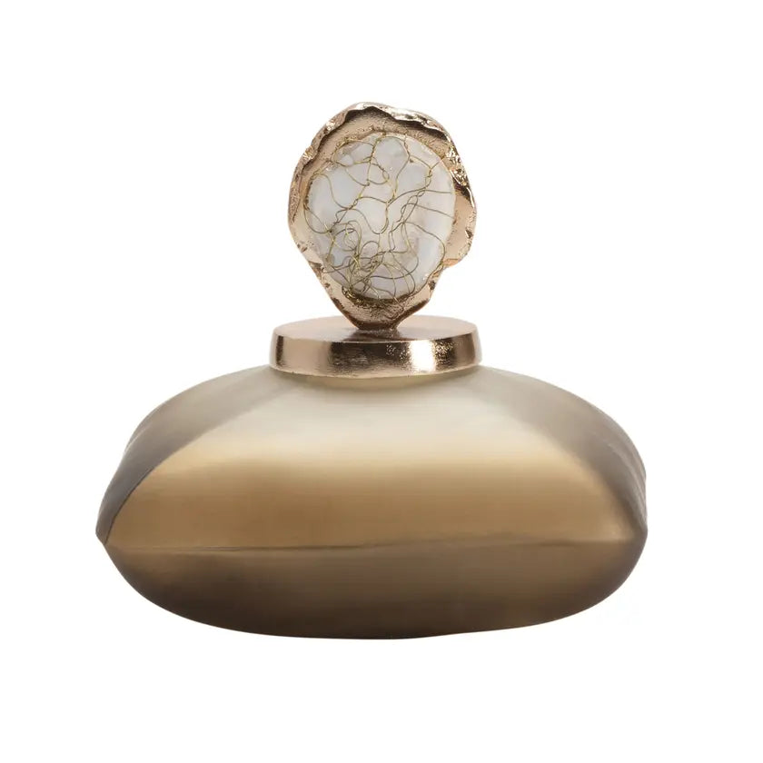 A gold-colored bottle accent with a textured surface and a rounded shape designed to sit on top of a bottle.