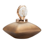 A gold-colored bottle accent with a textured surface and a rounded shape designed to sit on top of a bottle.