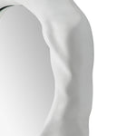 Close -up to a organic form mirror with a white background