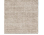 A rectangular taupe-colored area rug with a textured weave pattern.