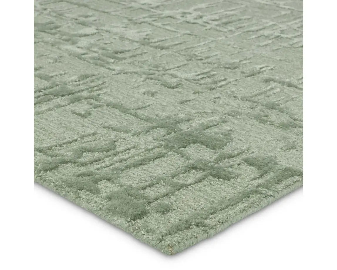 A rectangular, solid green area rug with a textured design.