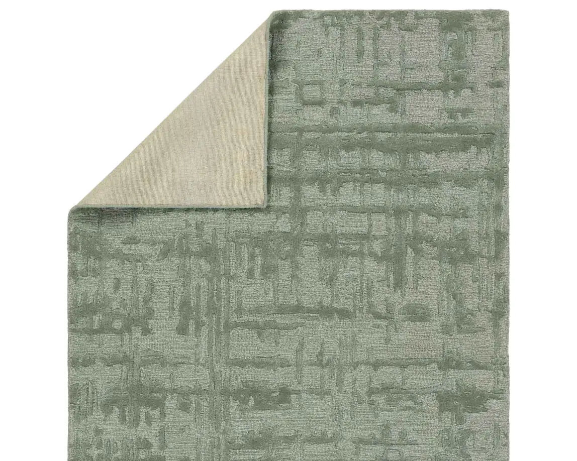 A rectangular, solid green area rug with a textured design.