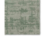A rectangular, solid green area rug with a textured design.