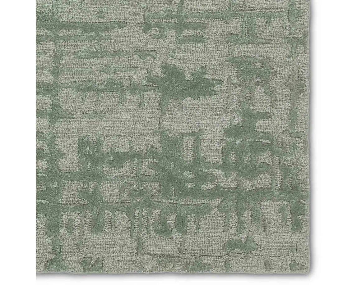 A rectangular, solid green area rug with a textured design.