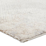 Close-up of a textured beige rug corner on a white background