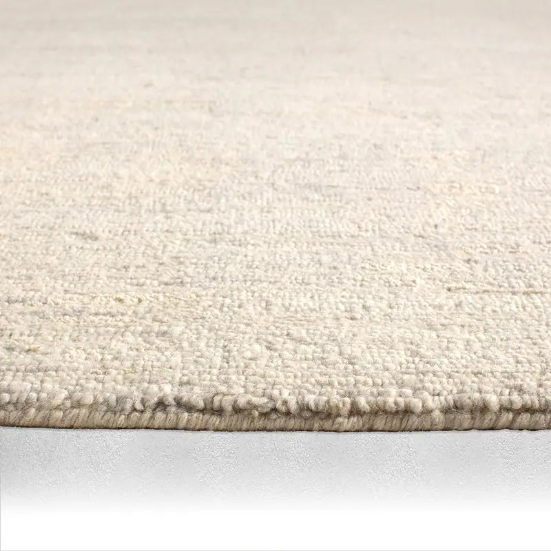 Close-up of a beige carpet on a light gray background