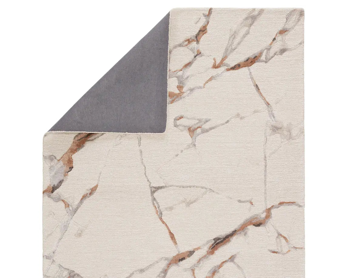 A rectangular area rug with a light gray color and a marble-like pattern, indicating a hand-tufted construction.