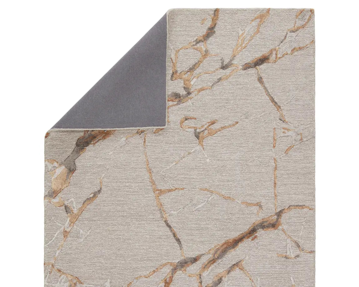 A dark dove and gold area rug with a textured surface featuring cracks and seams, resembling a natural stone or marble appearance.