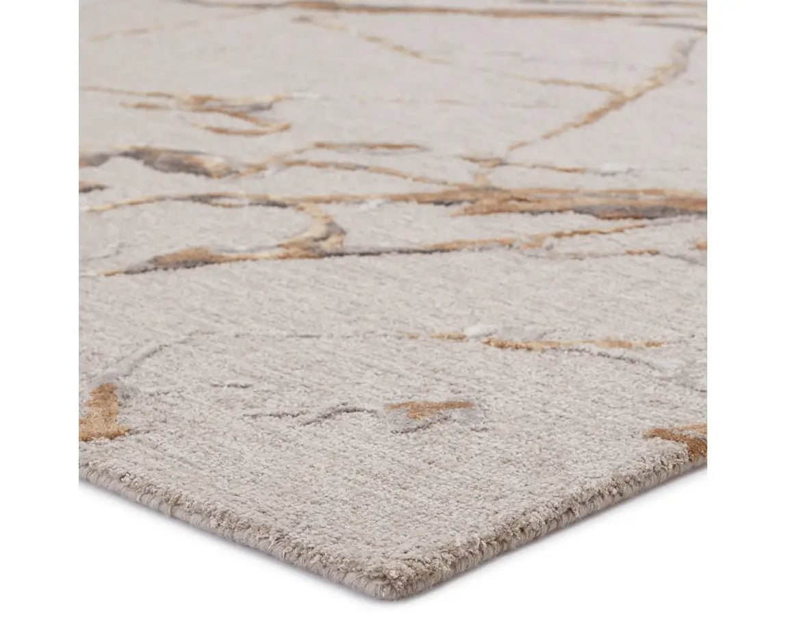 A dark dove and gold area rug with a textured surface featuring cracks and seams, resembling a natural stone or marble appearance.