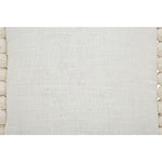 A square-shaped decorative pillow with solid pattern and pom pom detailing on the edges, primarily in a natural white color.