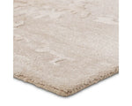 A beige and gray area rug with a textured design, hand tufted construction, and a viscose and wool blend.