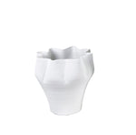 White ceramic vase with wavy design on a white background