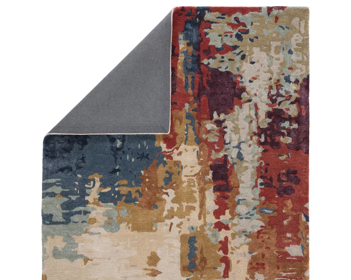 A rectangular area rug featuring a geometric pattern with a mix of blue, red, and beige colors.