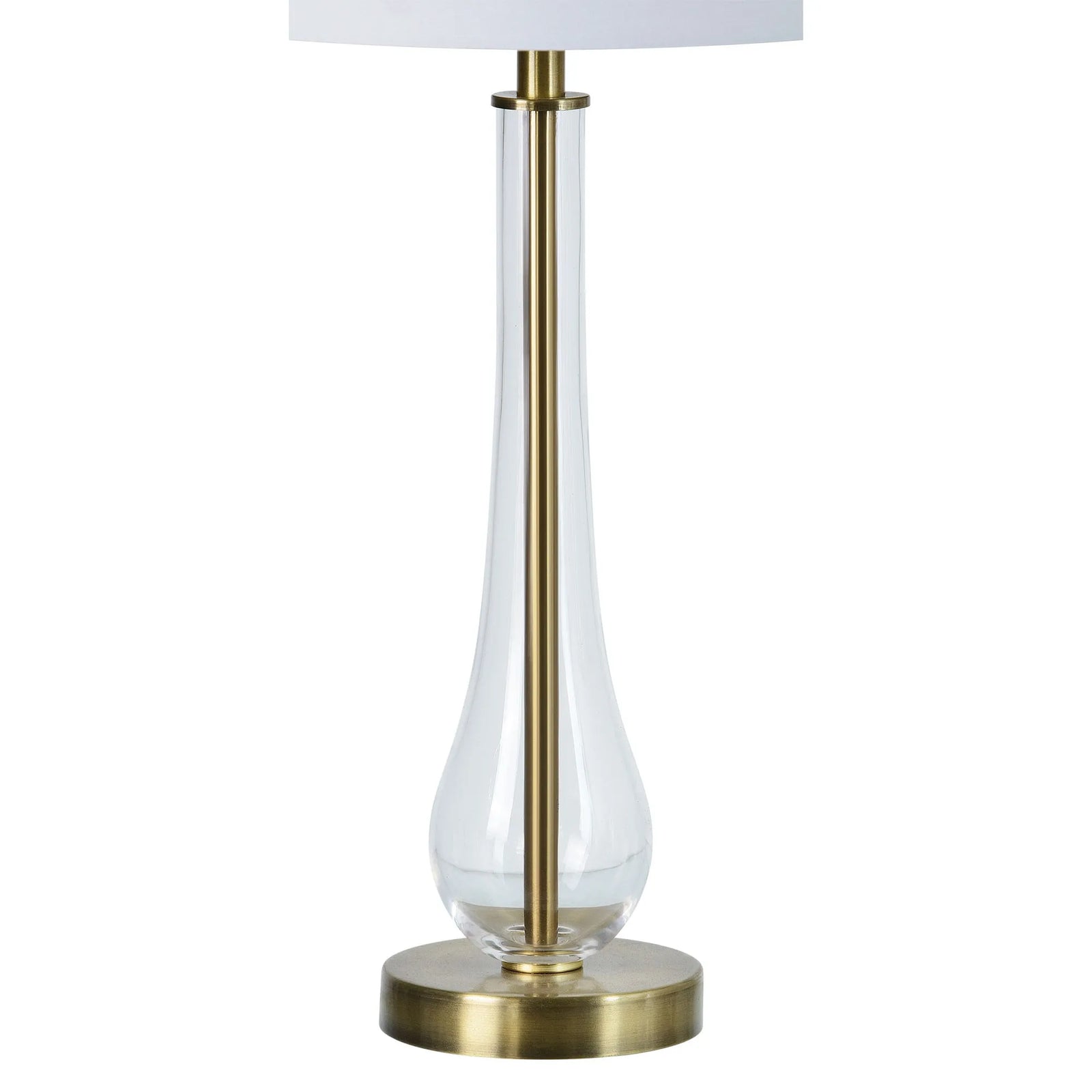 Table lamp with clear glass shade and brass base on a white background