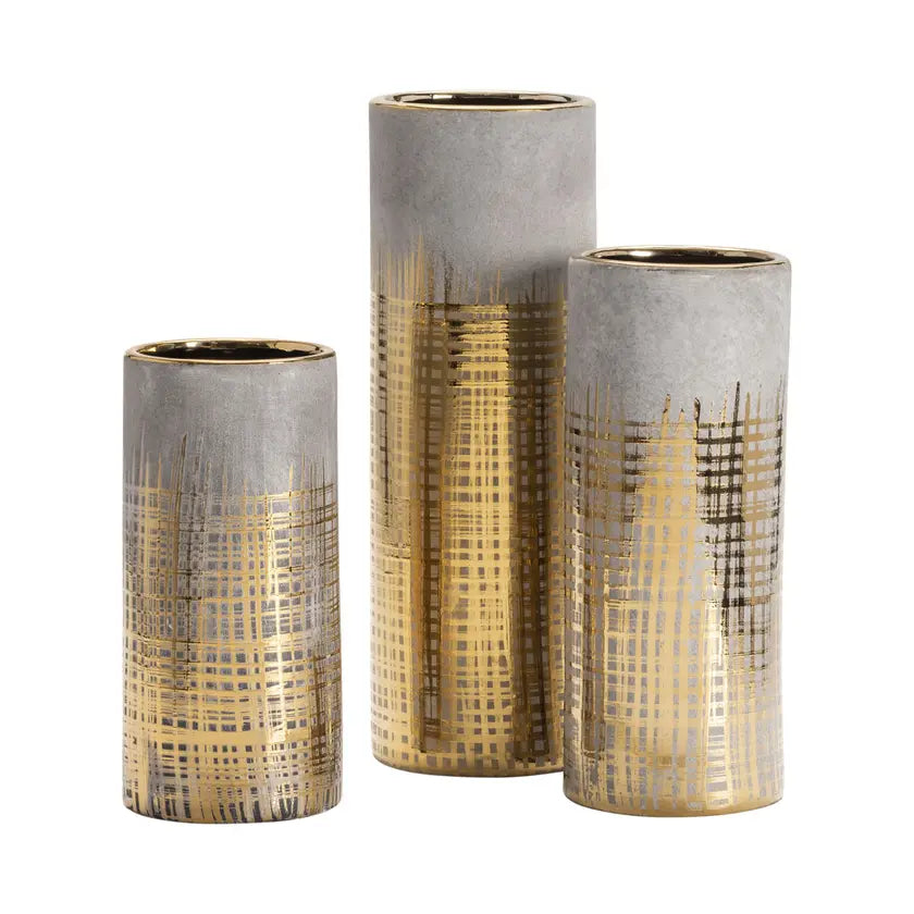 A set of three cylindrical decorative vases with gold geometric patterns on a gray background.