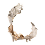 A decorative object with an irregular shape, featuring metallic gold and silver finishes.