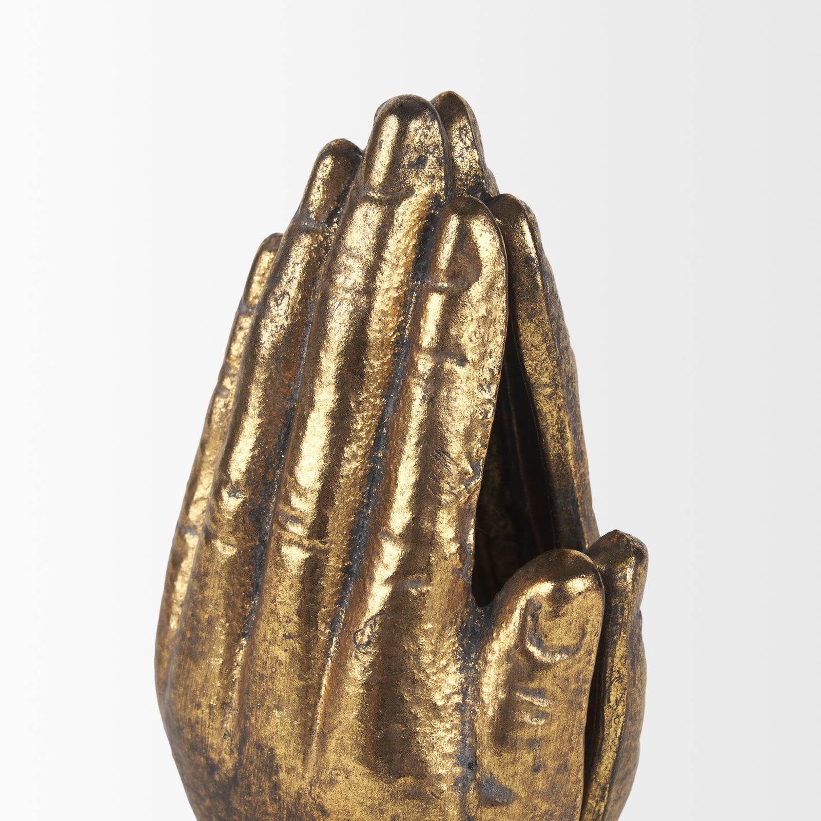 A gold-colored cast iron hand-shaped bookend.