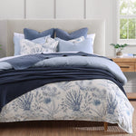 Bed with blue and white floral bedding in a bedroom setting